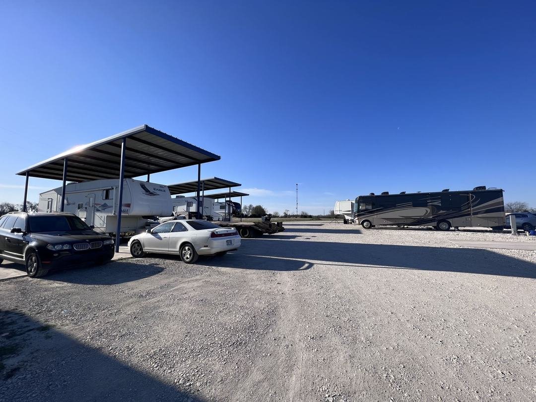 Row of covered RV sites with trailers parked at North Texas RV Park