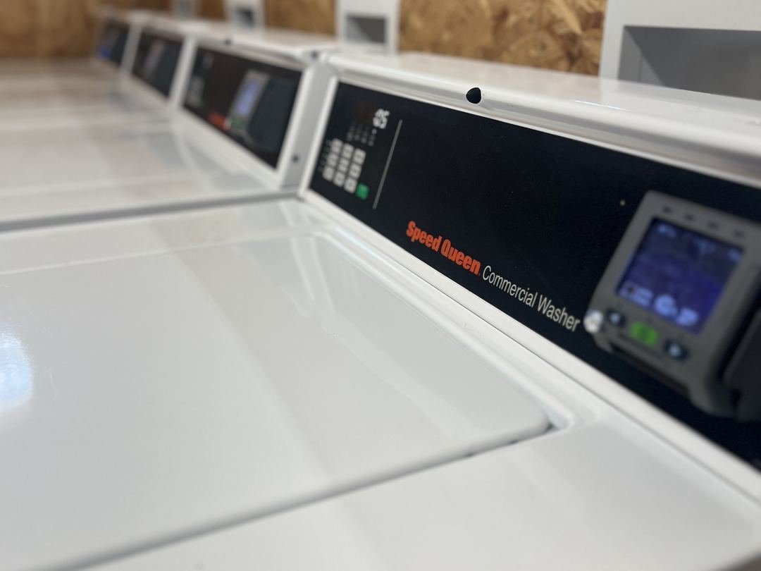Row of Speed Queen commercial washers in the on-site laundry facility