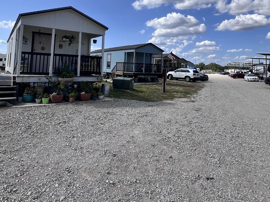 Row of tiny homes with covered porches under a blue Texas sky