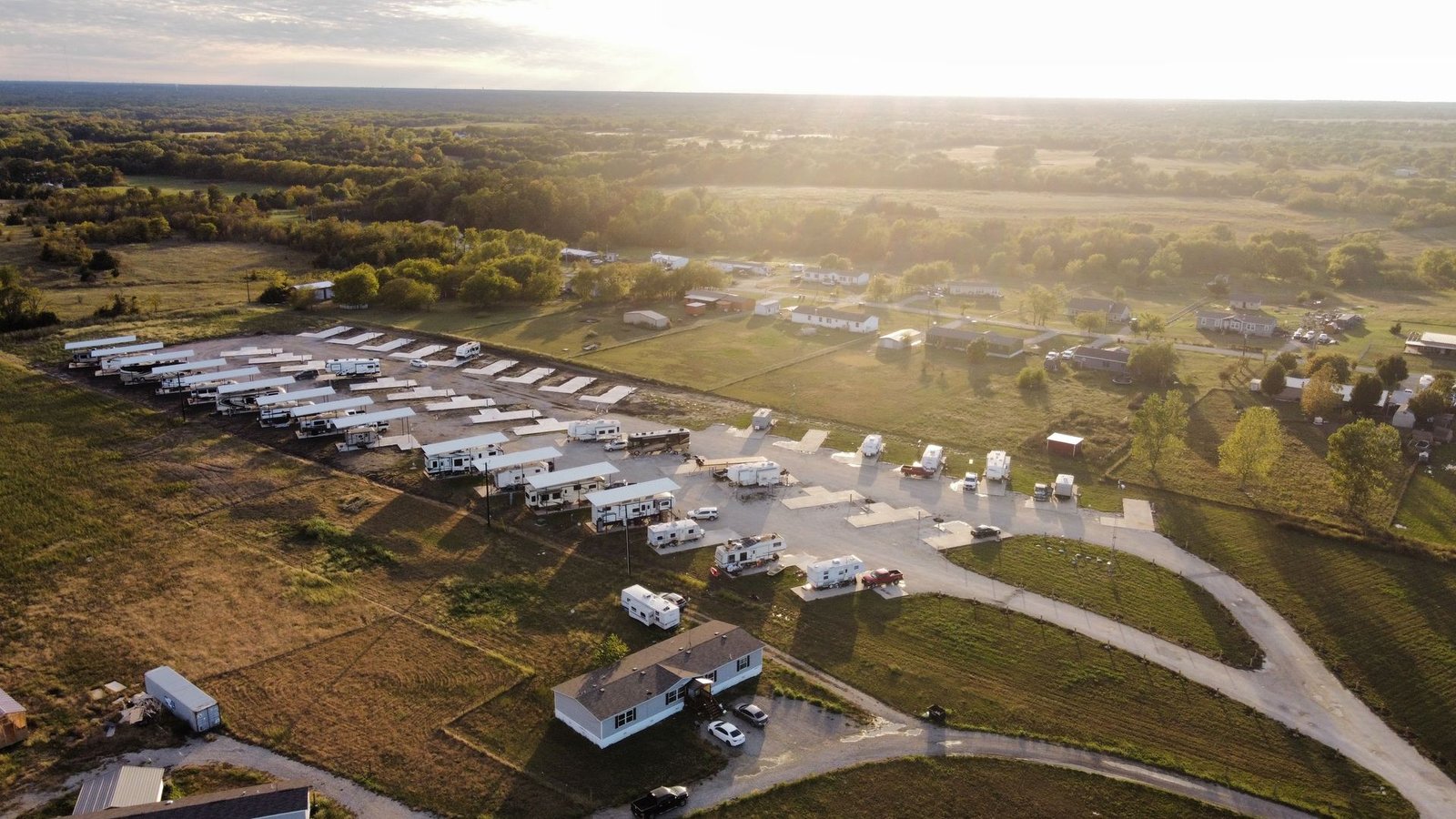 Aerial view of North Texas RV Park at golden hour, showing full rows of covered RV sites